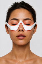 Femme portant le masseur oculaire LED Satilune, lumière rouge sur le contour des yeux